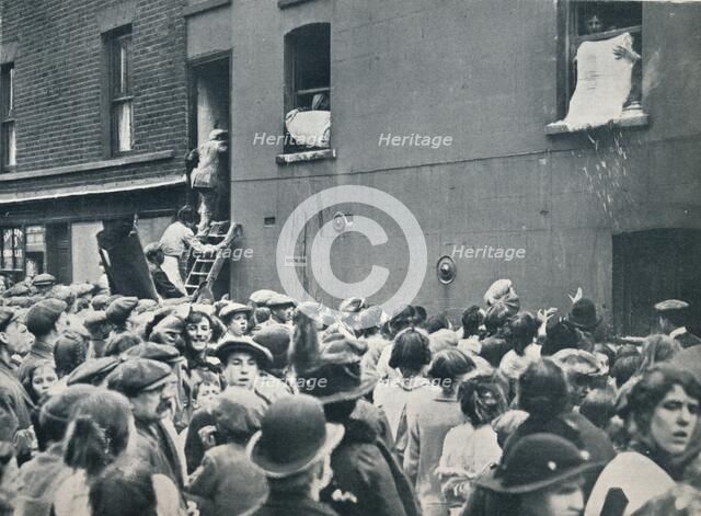 Crowd watching the looting of a German house in Poplar, c1914. Artist: Unknown