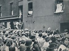 Crowd watching the looting of a German house in Poplar, c1914