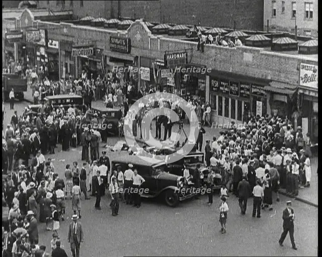 Crowded New York City Street Where Police and Ambulance Attend to Dead and Dying Victims..., 1932. Creator: British Pathe Ltd.