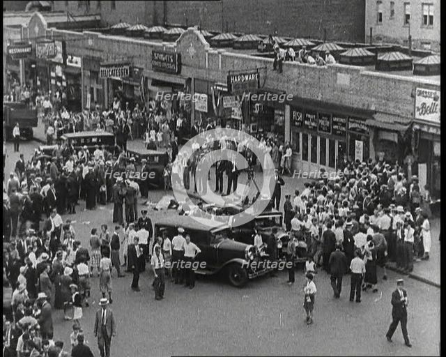 Crowded New York City Street Where Police and Ambulance Attend to Dead and Dying Victims..., 1932. Creator: British Pathe Ltd.