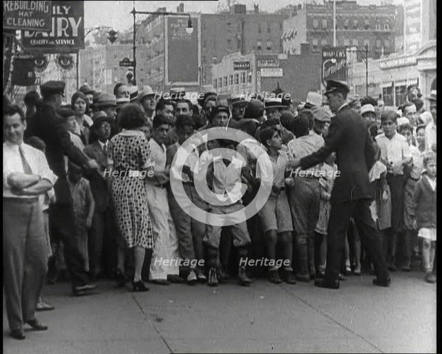Crowded New York City Street Where Police and Ambulance Attend to Dead and Dying Victims..., 1932. Creator: British Pathe Ltd.