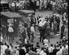 Crowded New York City Street Where Police and Ambulance Attend to Dead and Dying Victims..., 1932. Creator: British Pathe Ltd