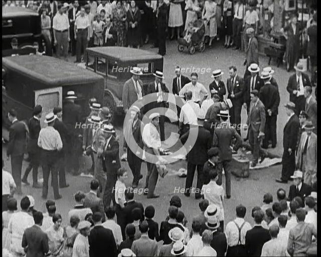 Crowded New York City Street Where Police and Ambulance Attend to Dead and Dying Victims..., 1932. Creator: British Pathe Ltd.