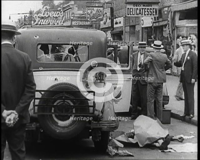Crowded New York City Street Where Police and Ambulance Attend to Dead and Dying Victims..., 1932. Creator: British Pathe Ltd.