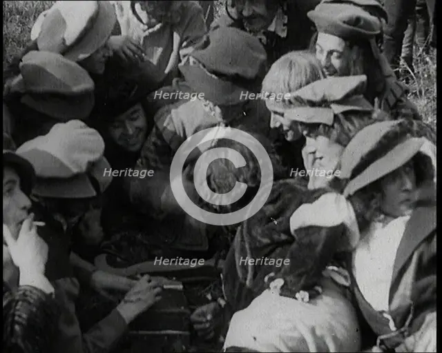Crowds of Female Actors Wearing Period Costumes Smoking Cigarettes Whilst Filming..., 1920s. Creator: British Pathe Ltd.