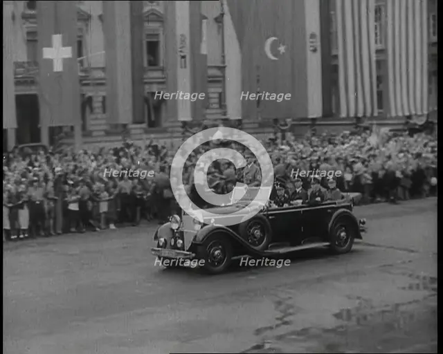 Crowds Watching a Car Drive Through Berlin, 1936. Creator: British Pathe Ltd.