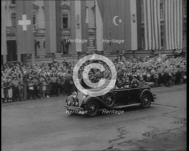Crowds Watching a Car Drive Through Berlin, 1936. Creator: British Pathe Ltd.