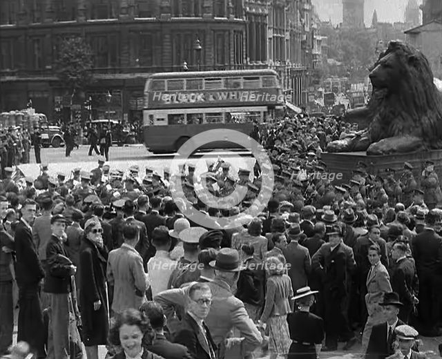Crowds Watching a Military Band March in Trafalgar Square, 1940. Creator: British Pathe Ltd.