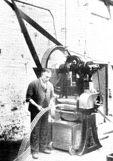 Cutting the familiar crosses: a metal-stamping machine, used in the making of rubber heels..., 1909. Creator: Unknown