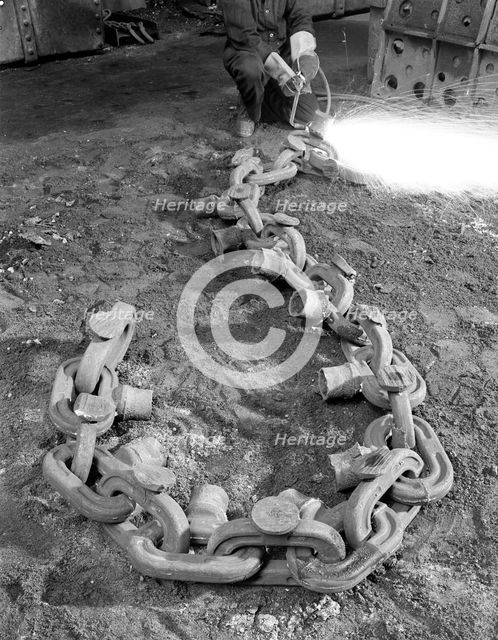 Cutting off lead from a manganese chain casting, Sheffield, South Yorkshire, 1965. Creator: Michael Walters.