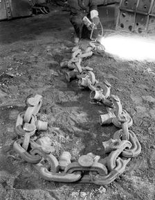 Cutting off lead from a manganese chain casting, Sheffield, South Yorkshire, 1965. Creator: Michael Walters