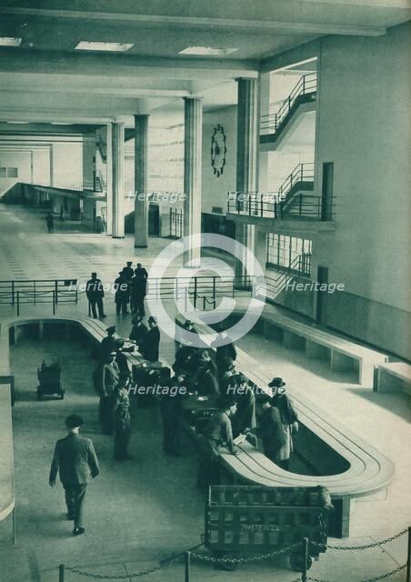 Customs officers examining passengers' baggage at Le Bourget Airport, Paris, 1937. Artist: Unknown.