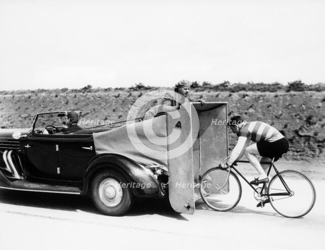 Cyclist training behind an Auburn car, c1935. Artist: Unknown