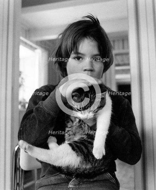A 5 year old boy with his pet cat. Creator: Unknown.