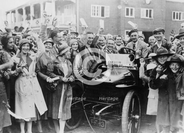 A 1904 Wolseley amidst a crowd of cheering people, Brooklands, Surrey, late 1920s-early 1930s. Artist: Unknown