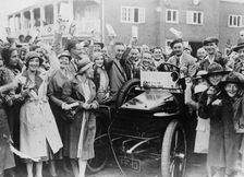 A 1904 Wolseley amidst a crowd of cheering people, Brooklands, Surrey, late 1920s-early 1930s