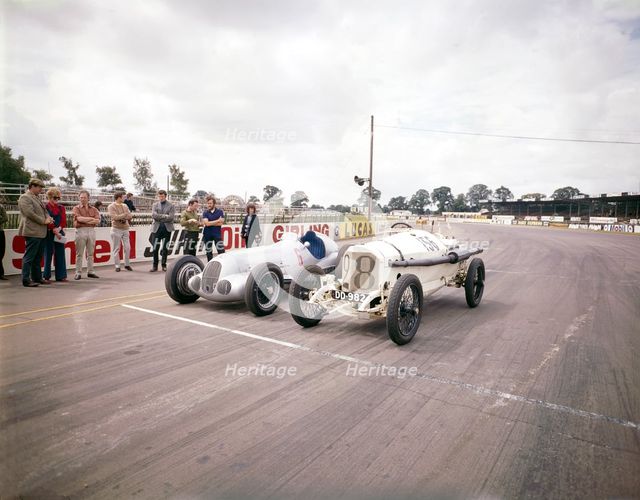 A 1914 and 1937 Grand Prix Mercedes racing cars at the starting line. Artist: Unknown
