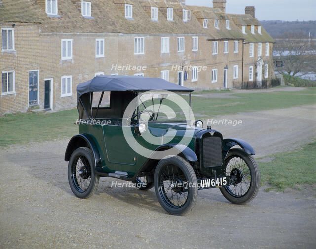 A 1929 Austin 7 in front of a row of terraced houses. Artist: Unknown