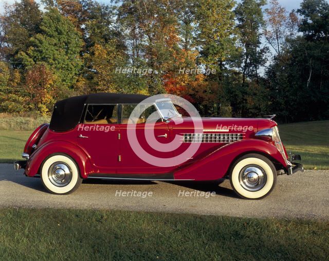 A 1936 Auburn 852 car on a gravel driveway in the autumn sunlight. Artist: Unknown