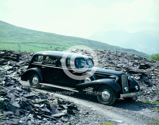 A 1937 Cadillac V16 sedan, photographed among piles of slate. Artist: Unknown