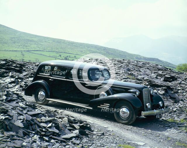 A 1937 Cadillac V16 sedan, photographed among piles of slate. Artist: Unknown