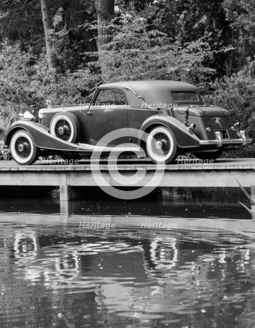 A 1933 Hispano-Suiza K6 reflected in a lake. Artist: Unknown
