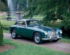 A 1952 Aston Martin DB2 saloon car photographed in a stately garden
