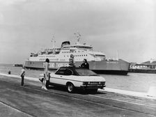 A 1974 Ford Capri on a quay, in front of a Townsend Thoresen car ferry, 1970s