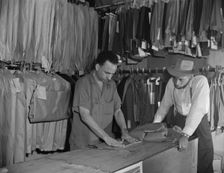 A tailor in Frank's cleaning and pressing establishment altering..., Washington, D.C., 1942. Creator: Gordon Parks
