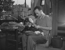 A tailor in Frank's cleaning and pressing establishment altering a pair..., Washington, D.C., 1942. Creator: Gordon Parks