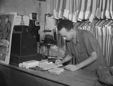 A tailor in Frank's cleaning and pressing establishment checking..., Washington, D.C., 1942. Creator: Gordon Parks