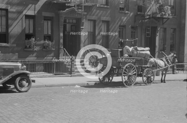 A tenant is moving on horse-drawn wagon, 61st Street between 1st and 3rd Avenues, New York, 1938. Creator: Walker Evans.