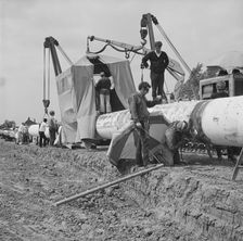 A team of men working on the lining up operation of the Fens gas pipeline, Norfolk, 24/07/1967. Creator: John Laing plc