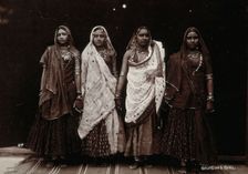 A troupe of nautch dancing girls, standing in a line holding hands, in a studio setting, c1900. Creator: Unknown