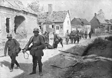 A travers le champ de bataille; prisonniers allemands traversant un village reconquis..., 1918. Creator: Unknown