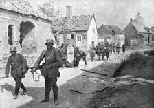 A travers le champ de bataille; prisonniers allemands traversant un village reconquis..., 1918. Creator: Unknown