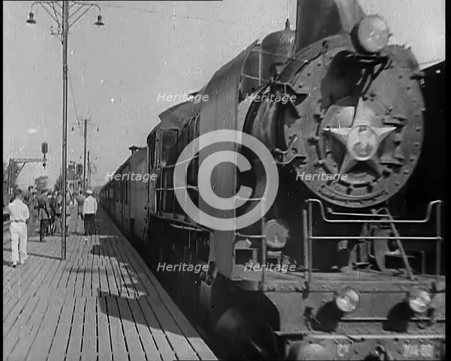 A Train Pulling Into a Station as Assorted Military Men Are Standing on the Platform, 1939. Creator: British Pathe Ltd.