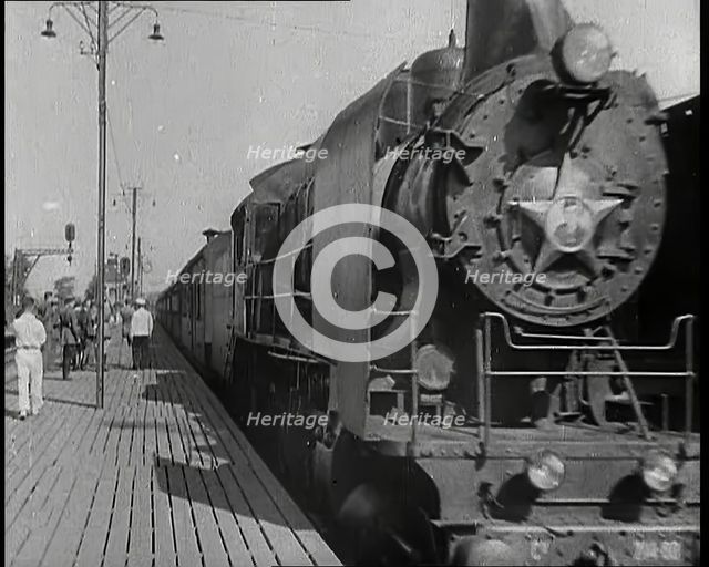 A Train Pulling Into a Station as Assorted Military Men Are Standing on the Platform, 1939. Creator: British Pathe Ltd.