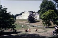 A view from the south-east looking towards Kenwood House, with people relaxing on the lawn..., 1984. Creator: Dorothy Chapman