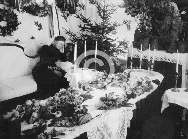 A widow grieving for her husband at a wake, Sweden. Artist: Unknown