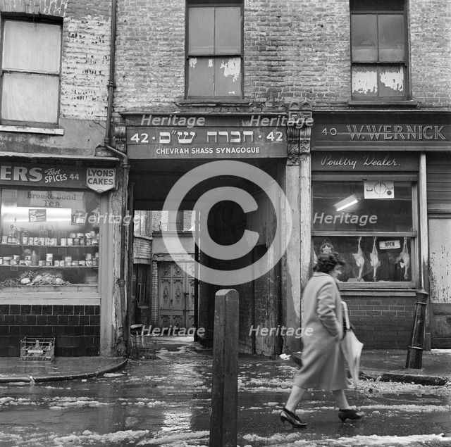 A woman walks past the Chevrah Shass Synagogue, Whitechapel, London c1946-c1959. Artist: John Gay