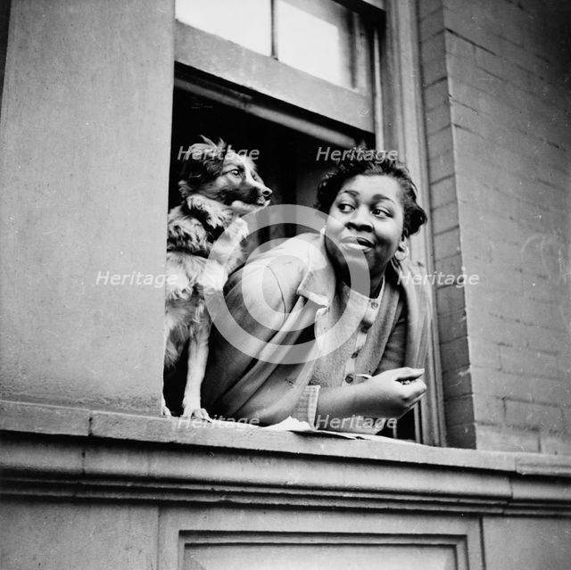 A woman and her dog in the Harlem section, New York, 1943. Creator: Gordon Parks.