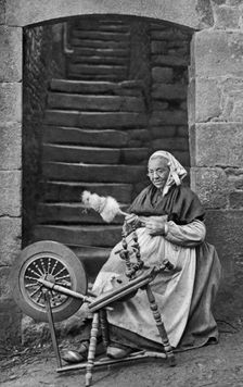 A woman at a spinning wheel, Dinan, Brittany, France, c1922