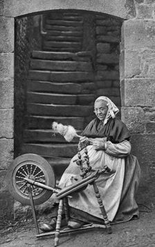 A woman at a spinning wheel, Dinan, Brittany, France, c1922