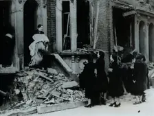 A woman collects her belongings from a bombed house, London, World War II, c1940-c1945. Creator: Unknown