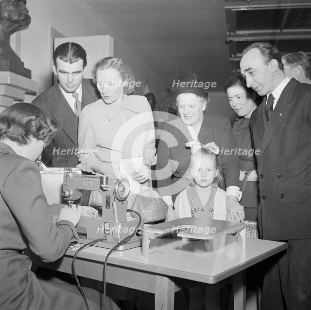 A woman demonstrates a sewing machine, Landskrona, Sweden, 1951.     Creator: Unknown.