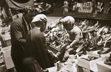 A woman from Harlem buys a pair of shoes for her child, New York, USA, c1920s-c1930s. Creator: Unknown