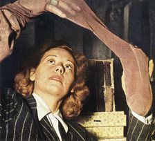 A woman in Paris examines a pair of silk stockings, 1941