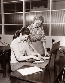 A woman is shown how to use an adding machine, York, Yorkshire, 1961
