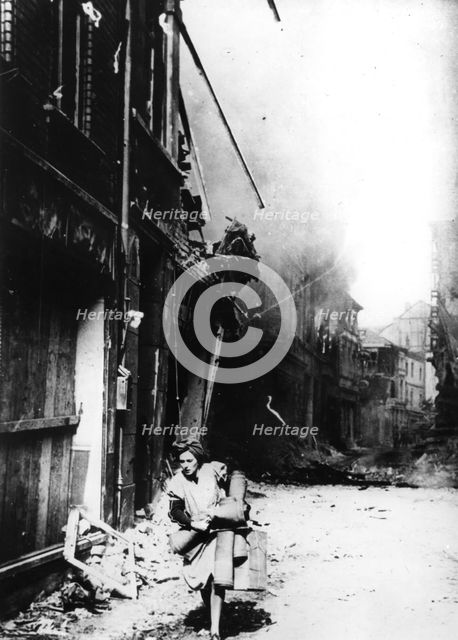 A woman leaving her burning house in a bombed street, Germany, 1945. Artist: Unknown